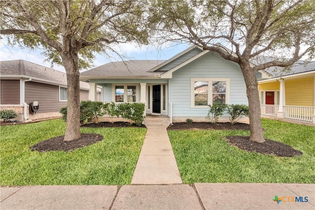 ranch-style home with roof with shingles and a front yard