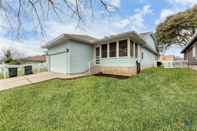 ranch-style house featuring a garage, driveway, a front yard, and fence