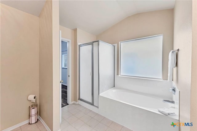 bathroom with a stall shower, tile patterned floors, lofted ceiling, and a bath