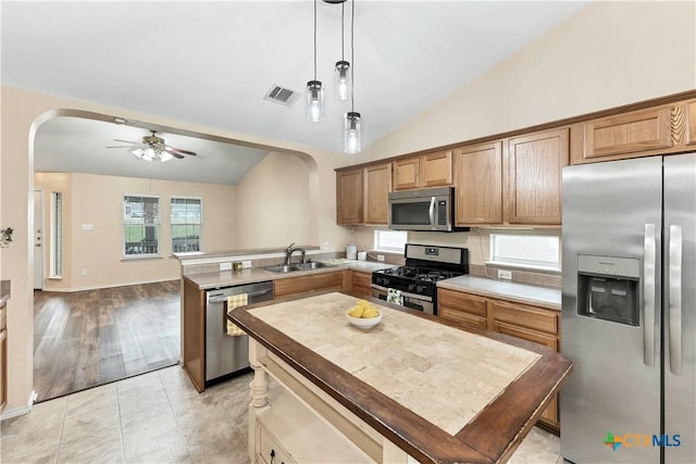 kitchen featuring stainless steel appliances, arched walkways, visible vents, and a sink