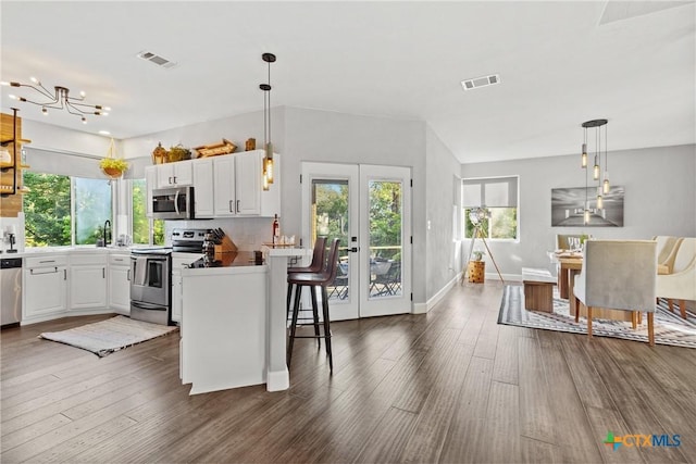 2201 Fuller Ln, Harker Heights, TX 76548 - kitchen with appliances with stainless steel finishes, dark wood-style floors, white cabinets, and decorative light fixtures