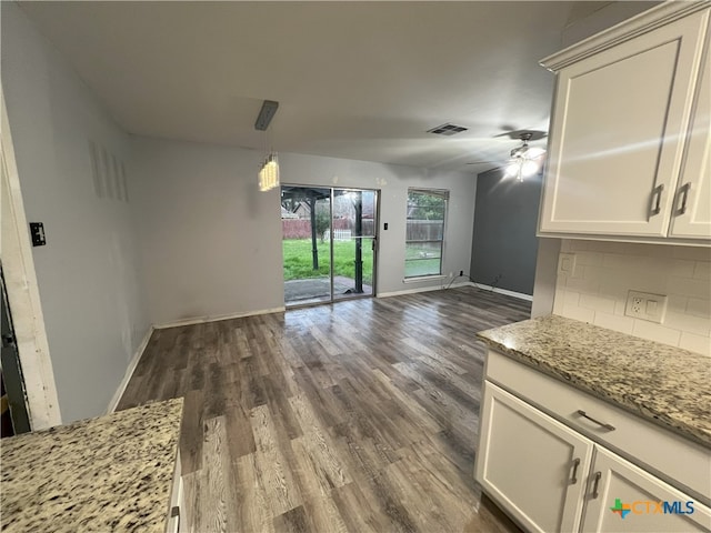 unfurnished dining area featuring dark wood-type flooring and ceiling fan