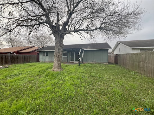 rear view of house featuring a lawn