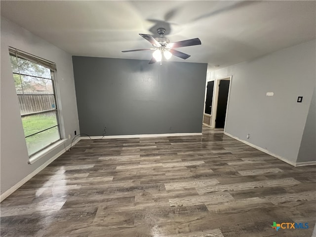 unfurnished room featuring dark wood-type flooring and ceiling fan