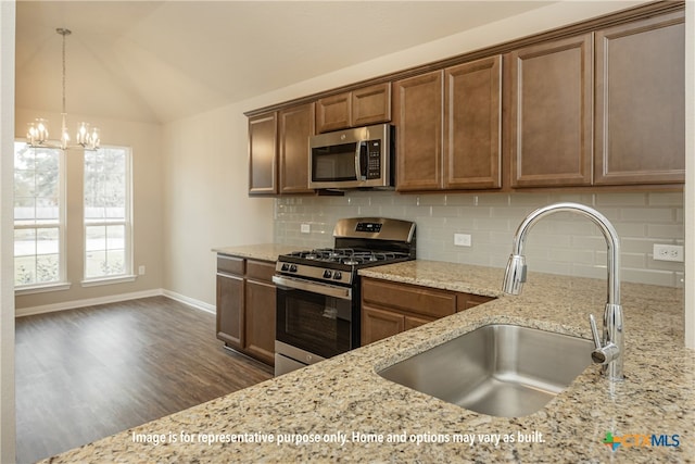 kitchen featuring lofted ceiling, sink, dark hardwood / wood-style floors, backsplash, and appliances with stainless steel finishes