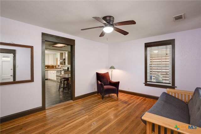 sitting room with ceiling fan and dark hardwood / wood-style flooring