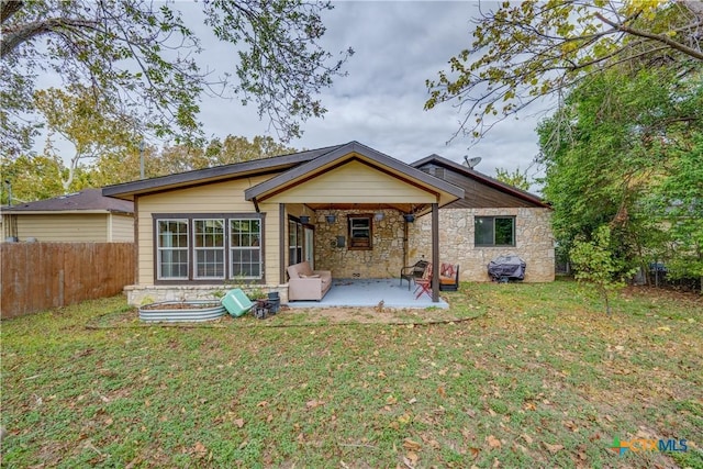 back of house with a lawn and a patio