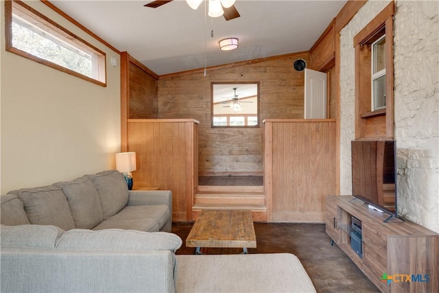 living room featuring wooden walls, ceiling fan, a healthy amount of sunlight, and lofted ceiling