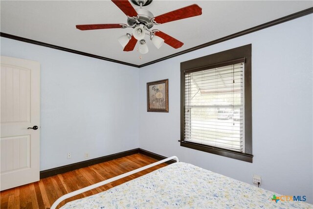 unfurnished bedroom featuring wood-type flooring, ceiling fan, and crown molding