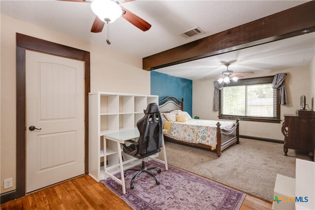 bedroom featuring beamed ceiling, hardwood / wood-style flooring, and ceiling fan