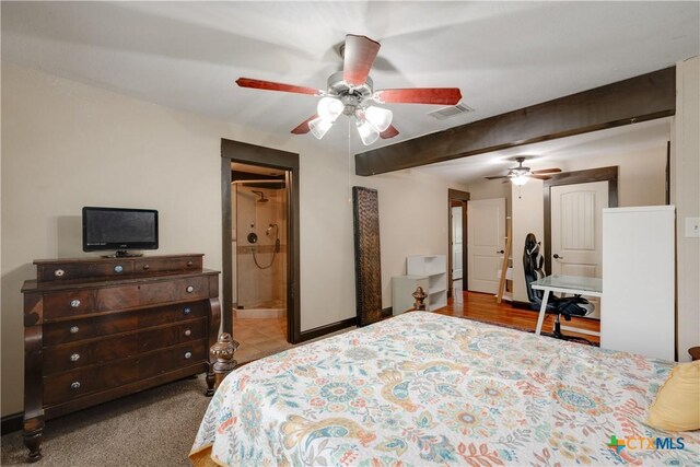 carpeted bedroom with beamed ceiling, ceiling fan, and ensuite bath