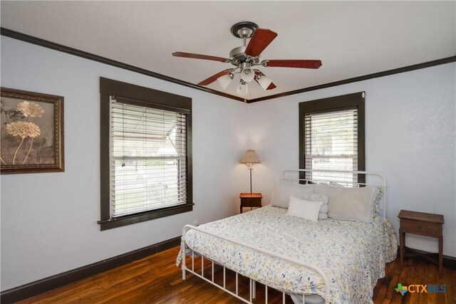 bedroom featuring ceiling fan, dark hardwood / wood-style flooring, and crown molding