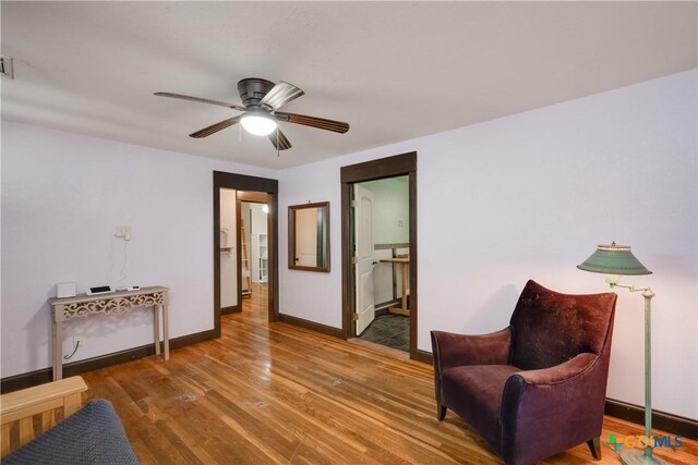 living area with ceiling fan and wood-type flooring