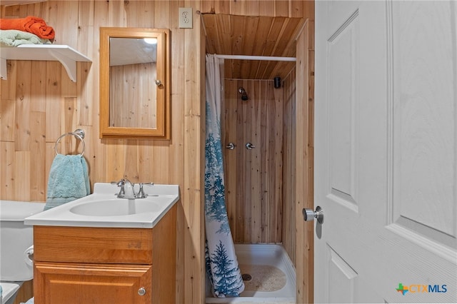 bathroom with vanity, wood walls, and a shower with shower curtain