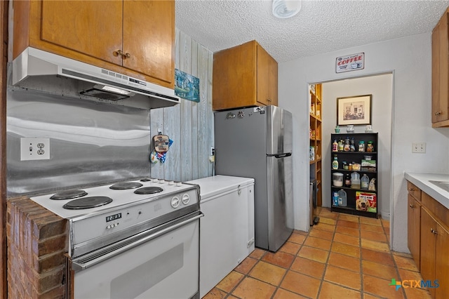 kitchen featuring stainless steel fridge, light tile patterned floors, a textured ceiling, and white range with electric stovetop