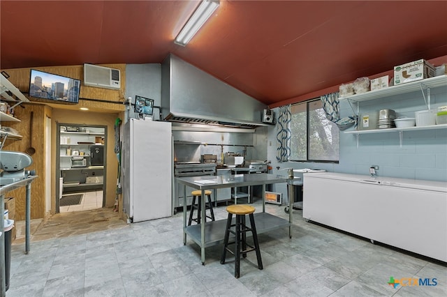 kitchen with fridge, range, and lofted ceiling