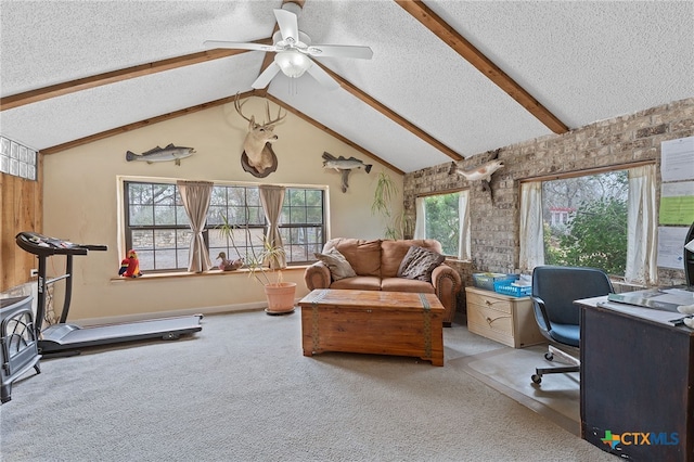 office space with vaulted ceiling with beams, a textured ceiling, a wood stove, ceiling fan, and carpet