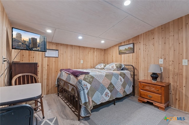 bedroom with wooden walls and wood-type flooring