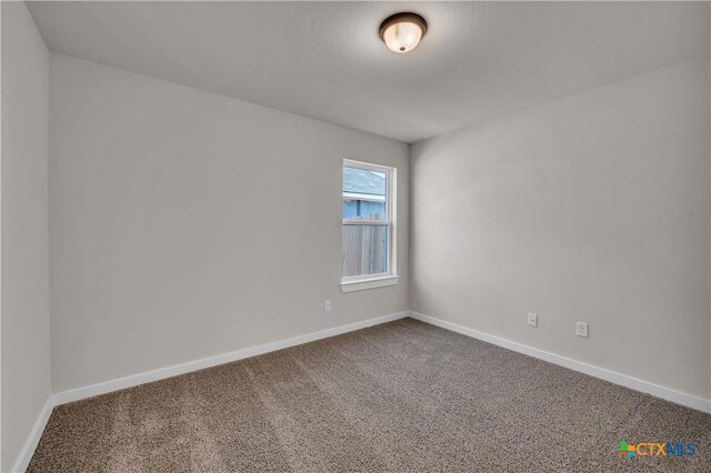 unfurnished bedroom with ensuite bath, a textured ceiling, and carpet