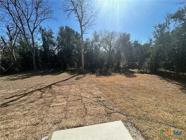 view of yard featuring a forest view and fence