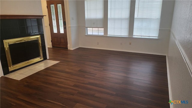 unfurnished living room featuring hardwood / wood-style flooring and a tile fireplace