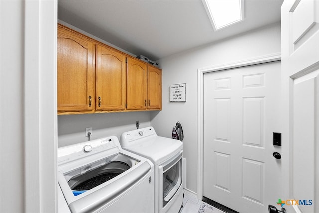 clothes washing area featuring cabinets and washing machine and dryer