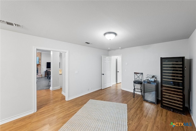 interior space featuring hardwood / wood-style flooring, a textured ceiling, and wine cooler