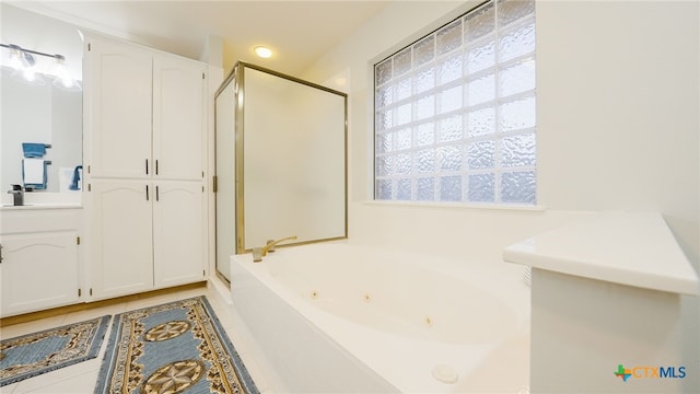 bathroom with independent shower and bath, vanity, and tile patterned floors