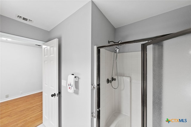 bathroom with an enclosed shower and wood-type flooring