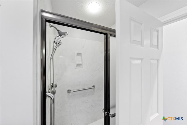 details with walk in shower and a textured ceiling