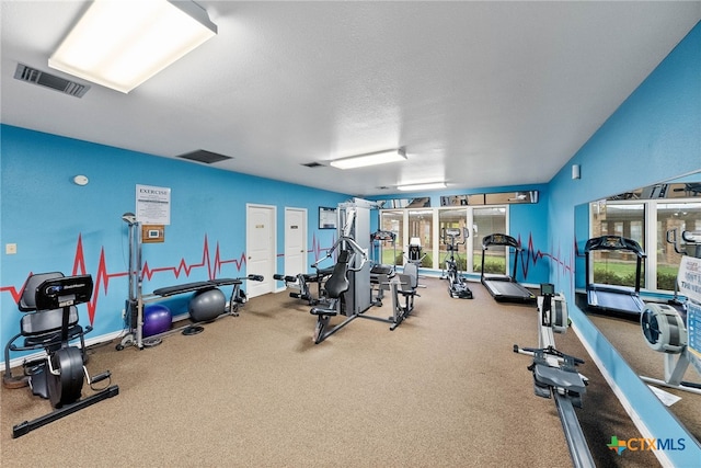 exercise room with a textured ceiling and a healthy amount of sunlight