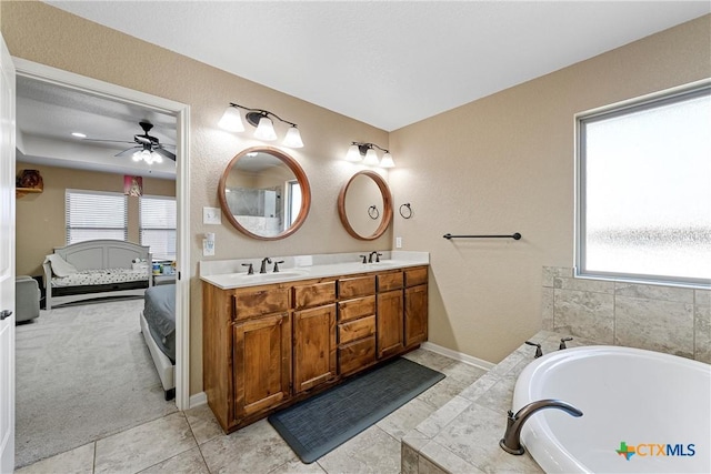 bathroom with vanity, tile patterned flooring, a bathtub, and a wealth of natural light