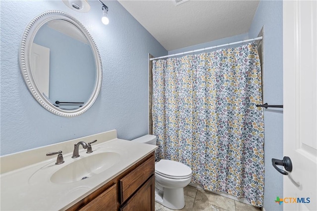 bathroom with vanity, toilet, tile patterned flooring, and a textured ceiling