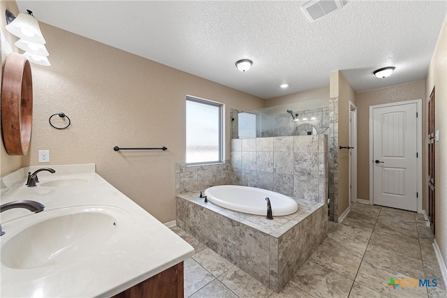 bathroom with vanity, a textured ceiling, and separate shower and tub