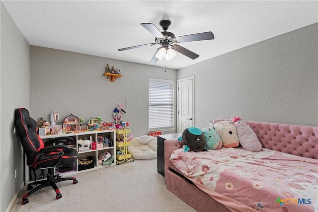 carpeted bedroom with ceiling fan and a textured ceiling