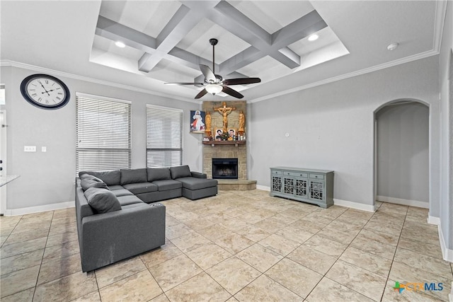 living room featuring light tile patterned floors, beam ceiling, coffered ceiling, ornamental molding, and a stone fireplace