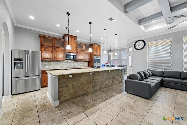 kitchen with coffered ceiling, decorative light fixtures, appliances with stainless steel finishes, a kitchen island with sink, and decorative backsplash