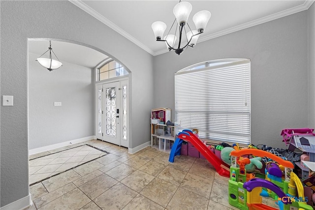 tiled foyer featuring ornamental molding and a notable chandelier