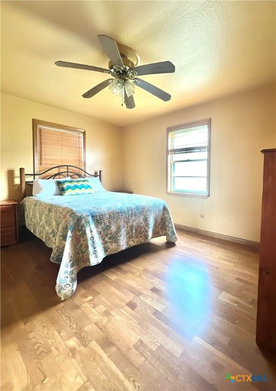 6769 Cedar Cove Rd, Belton, TX 76513 - bedroom with wood finished floors, baseboards, and a ceiling fan