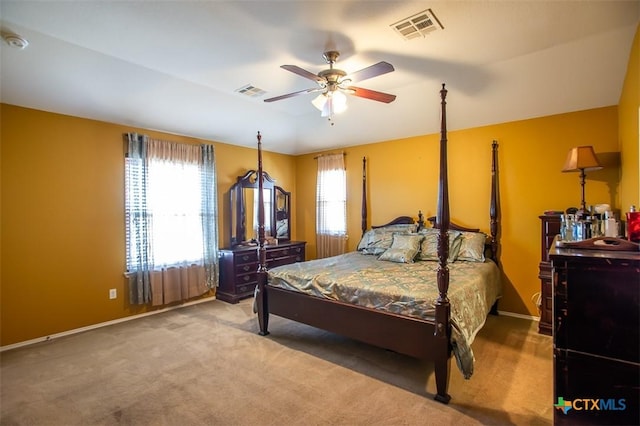 carpeted bedroom with visible vents, baseboards, and a ceiling fan