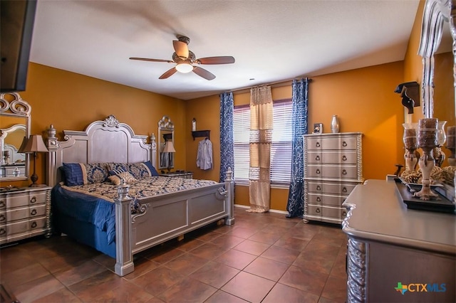 bedroom featuring baseboards, a ceiling fan, and dark tile patterned flooring