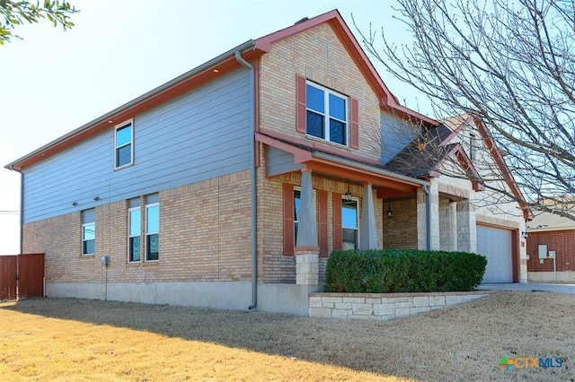 view of side of property featuring a yard, brick siding, and driveway