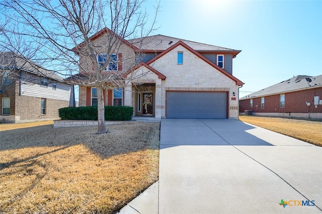 view of front of property with a garage, stone siding, concrete driveway, and a front yard