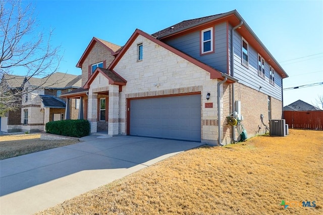 view of front of property featuring central AC unit, driveway, a garage, stone siding, and brick siding