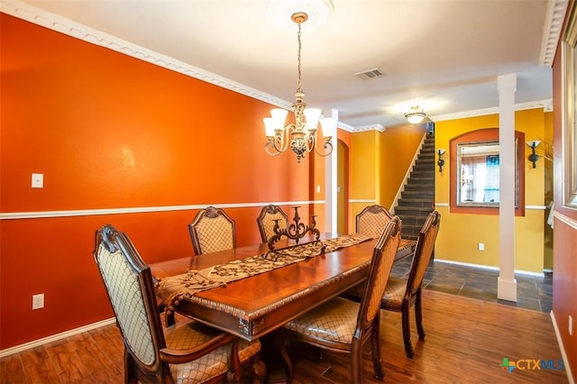 dining area featuring crown molding, stairway, wood finished floors, and visible vents