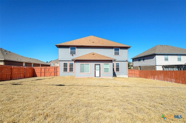 back of property with a yard and a fenced backyard