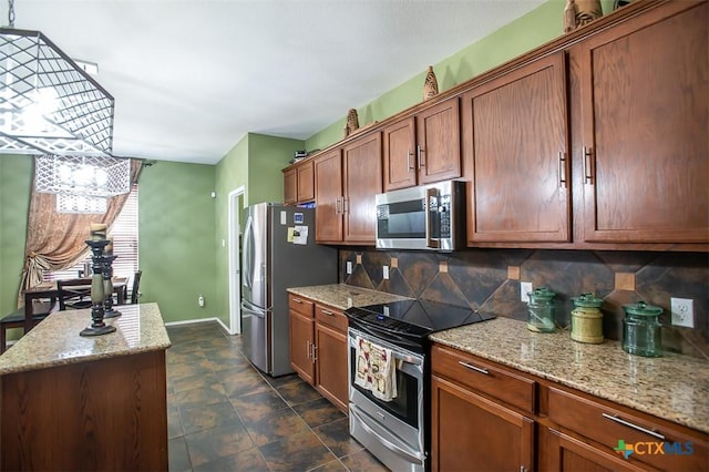 kitchen featuring tasteful backsplash, baseboards, light stone counters, brown cabinets, and appliances with stainless steel finishes