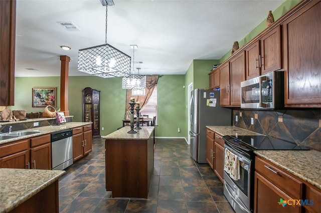 kitchen featuring tasteful backsplash, visible vents, a center island, stainless steel appliances, and a sink