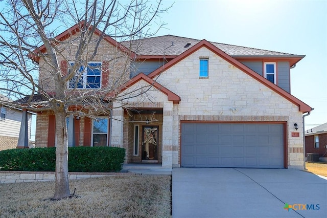 view of front of house with stone siding, driveway, a shingled roof, and a garage