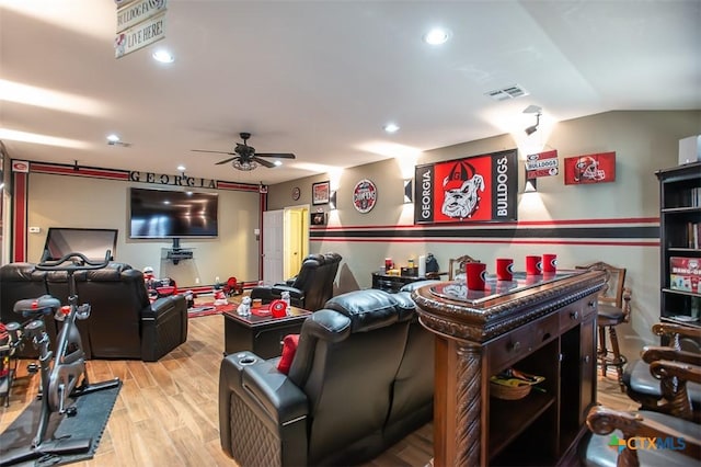 home theater featuring visible vents, ceiling fan, vaulted ceiling, recessed lighting, and wood finished floors